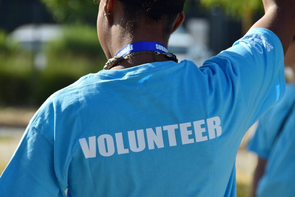 A female in a blue volunteering t-shirt. Volunteering can be a good way to gain relevant experience in a new professional area