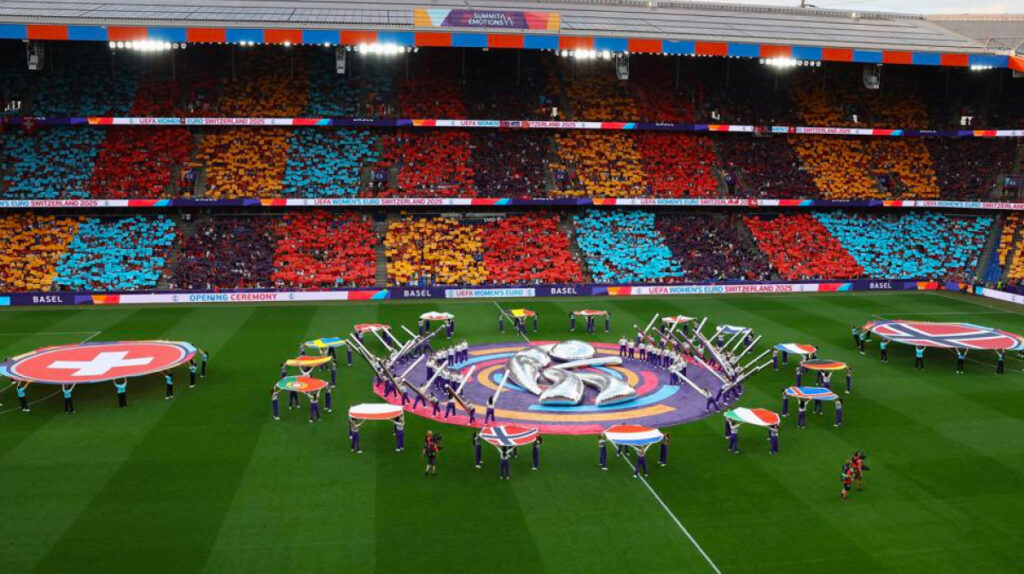 Colorful stadium view of the UEFA Women's EURO 2025 opening ceremony in Basel, Switzerland, featuring vibrant fan displays and national flags on the pitch.