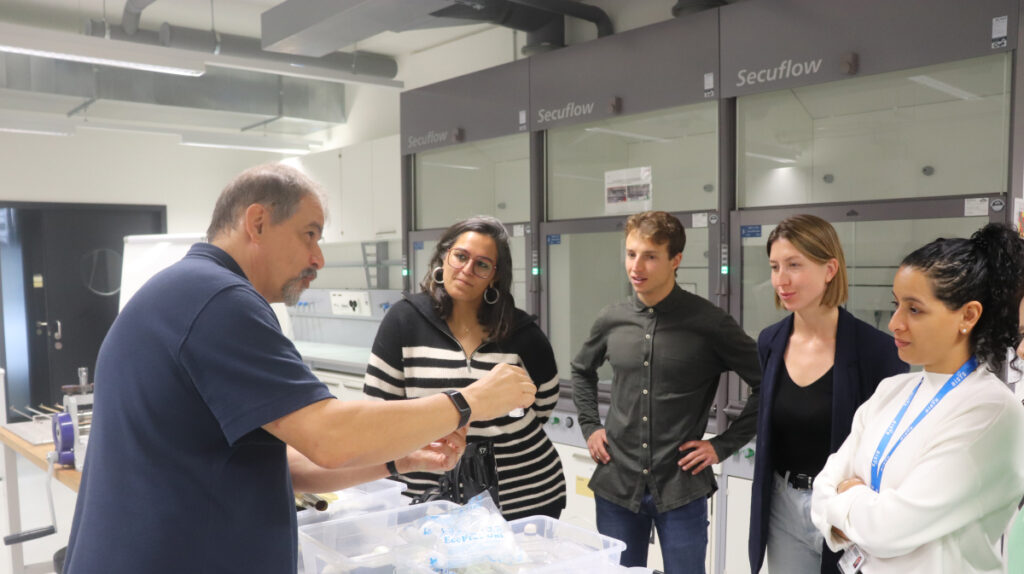 Instructor demonstrating equipment to students in a sports science lab connected to sports management education.