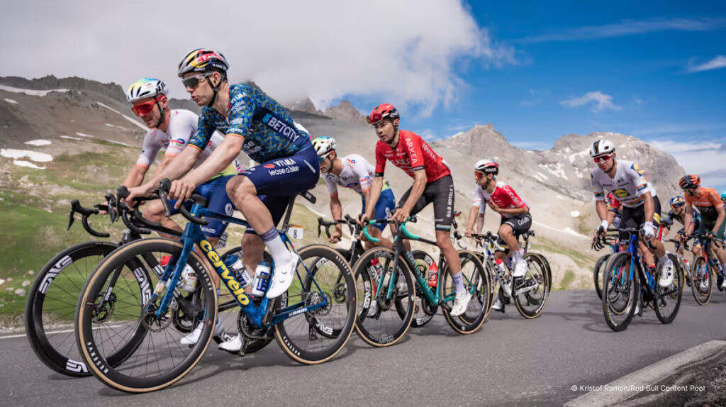 Peloton of cyclists climbing mountain road during stage race.