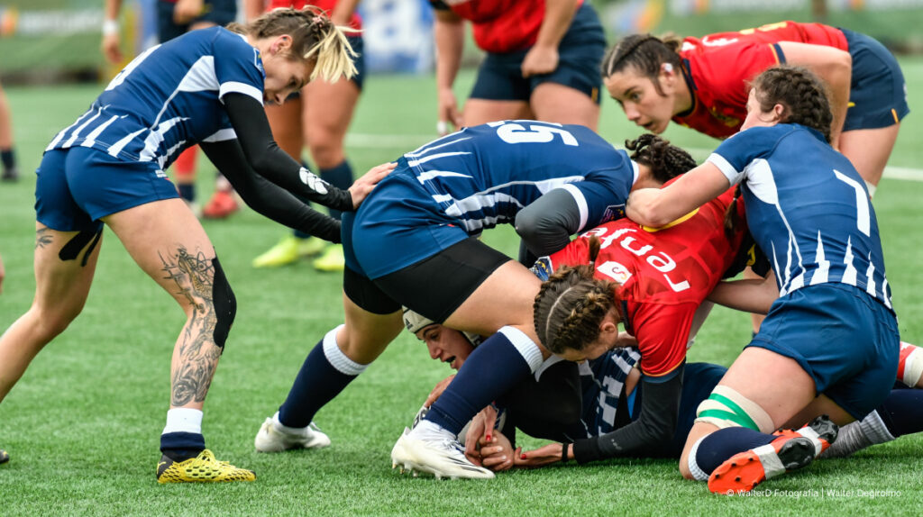 Women rugby players competing in tackle phase